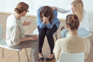 young despair woman crying during group therapy